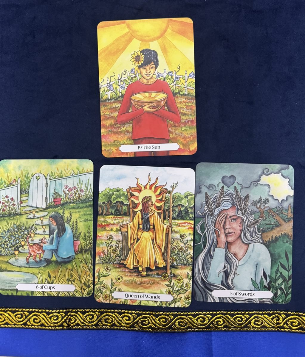 Tarot cards laid out on navy velvet with gold trim during a reading